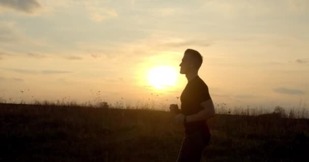 Młody facet biegnie off-road o zachodzie słońca w jesiennej pogodzie 4K — Wideo stockowe