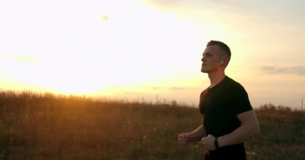 Junger Mann läuft bei Herbstwetter bei Sonnenuntergang von der Straße — Stockvideo