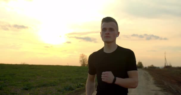 Молодой парень бежит по бездорожью на закате осенью 4K — стоковое видео