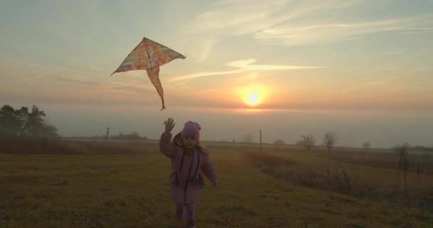 Une petite fille regarde un beau coucher de soleil et sourit. Gros plan sur le visage. 4k — Video