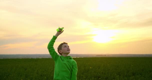 Un ragazzo sta giocando con un aquilone nel cielo al tramonto. 4K — Video Stock