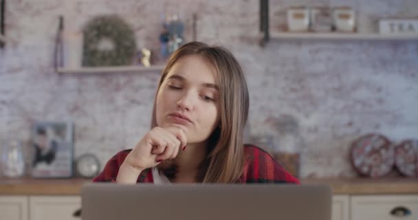 Genç bir kız dizüstü bilgisayarın yanında düşünüyor. Leptop 'ta çalış. 4K — Stok video