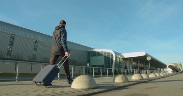 Le type avec la valise se dirige vers l'aéroport. Voyage en avion. Météo ensoleillée, 4K — Video