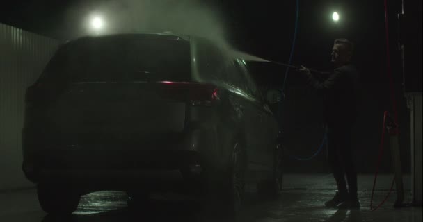 男はセルフサービスの車の洗浄4Kで車を洗っている。 — ストック動画
