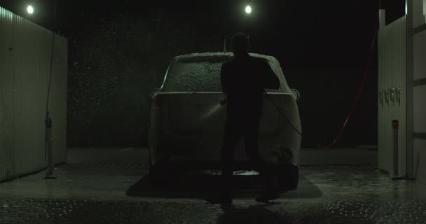 A guy is putting foam on a car at a self-service car wash. 4K — Stock Video