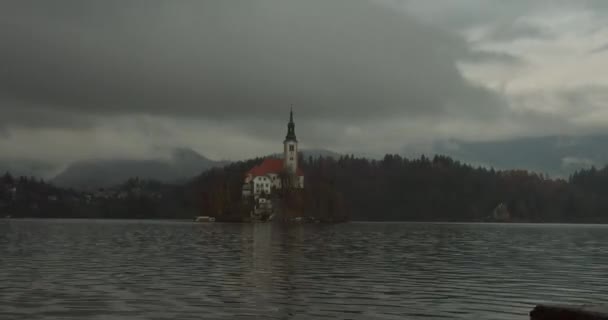 Igreja Timelapse em uma ilha no meio do lago Bled. Tempo nublado nas montanhas. Lake Bled, Eslovénia. 4K — Vídeo de Stock