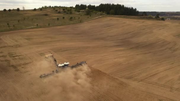 Tirer depuis un drone. Un tracteur cultive la terre. Préparation au semis. 4K 