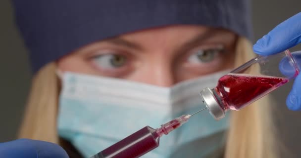 Bir laboratuvar çalışanı şırıngadan maddeye kan pompalıyor ve reaksiyonu izliyor. 4k — Stok video
