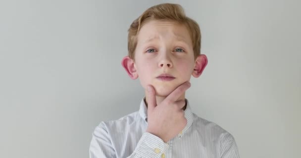 Close-up portret. De jongen denkt na en komt met een idee door zijn vinger op te steken. 4K — Stockvideo