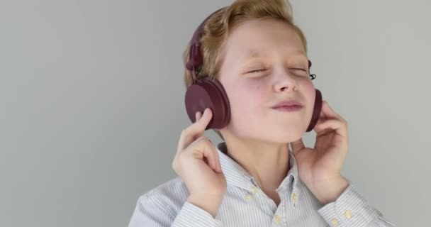クローズアップ肖像画。少年はヘッドフォンとダンスで音楽を聞いている。4K — ストック動画