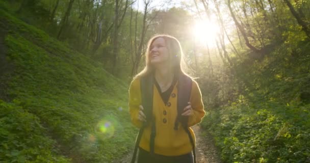 Disparos de cerca. Una chica sonriente camina por el bosque. Senderismo en el bosque. 4K — Vídeos de Stock