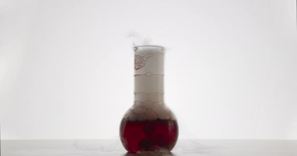 Dwie substancje chemiczne mieszają się w żarówce. Białe tło. 4k — Wideo stockowe