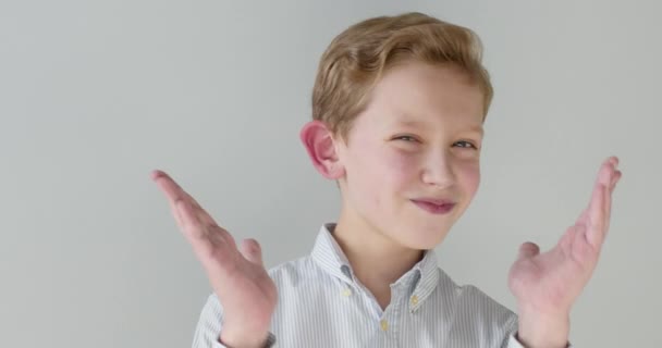 Yakın plan portre. Çocuk ellerini açıyor ve gülümsüyor. 4K — Stok video