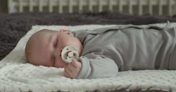 クローズアップ撮影。赤ん坊は眠っていて、ペースメーカーを吸っている。4k — ストック動画