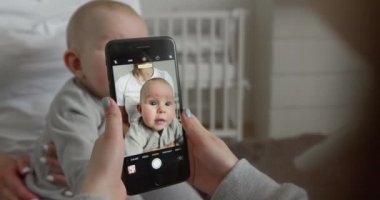 Yakın plan çekim. Bir kız bebeğiyle annesinin fotoğrafını çekiyor. 4k
