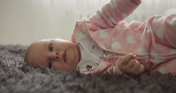 근접 촬영. 아기는 뛰면서 침대 위에서 돌아눕고 있다. 4K — 비디오