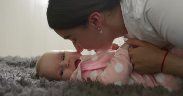 근접 촬영. 어미는 코로 아기의 뺨을 쓰다듬고 있다. 아기가 웃고 있어요. 4K — 비디오
