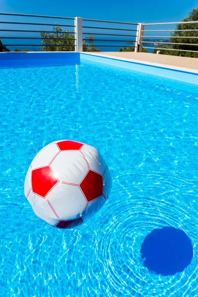 Pallone da spiaggia galleggiante sull'acqua in piscina — Foto Stock