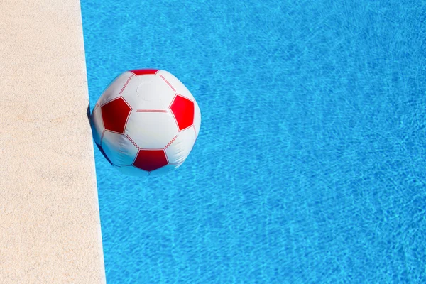 Pelota de playa roja y blanca flotando en la piscina —  Fotos de Stock
