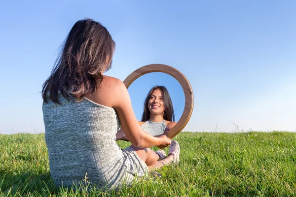 Mujer en la naturaleza viendo su imagen espejo —  Fotos de Stock