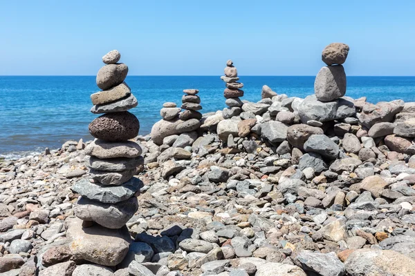 Piedras de playa apiladas en el mar azul — Foto de Stock