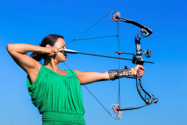 Jeune femme visant flèche de l'arc composé — Photo