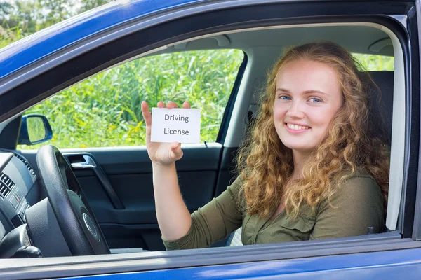 Unga holländska kvinnan visar kort körkort i bil — Stockfoto