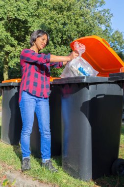 Plastik atık çöp kutusu içinde bırakarak Hollandalı kadın ayakta