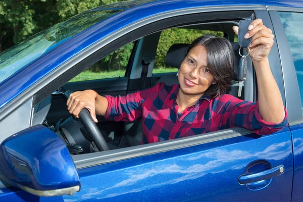 Mujer conduciendo coche mostrando la llave del coche —  Fotos de Stock