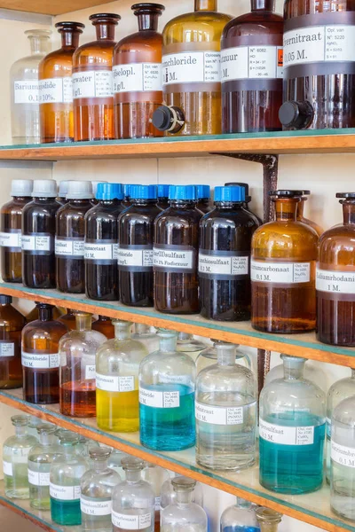 Rangées de produits chimiques fluides dans les bouteilles à l'enseignement de la chimie — Photo