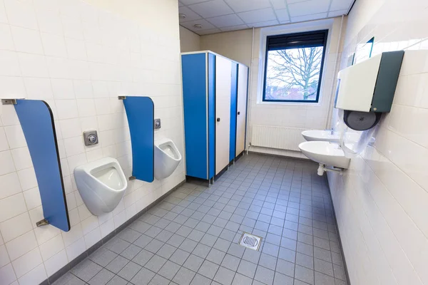 Toilet ruimte voor mannen met urinoirs wastafels en handdoek dispenser — Stockfoto