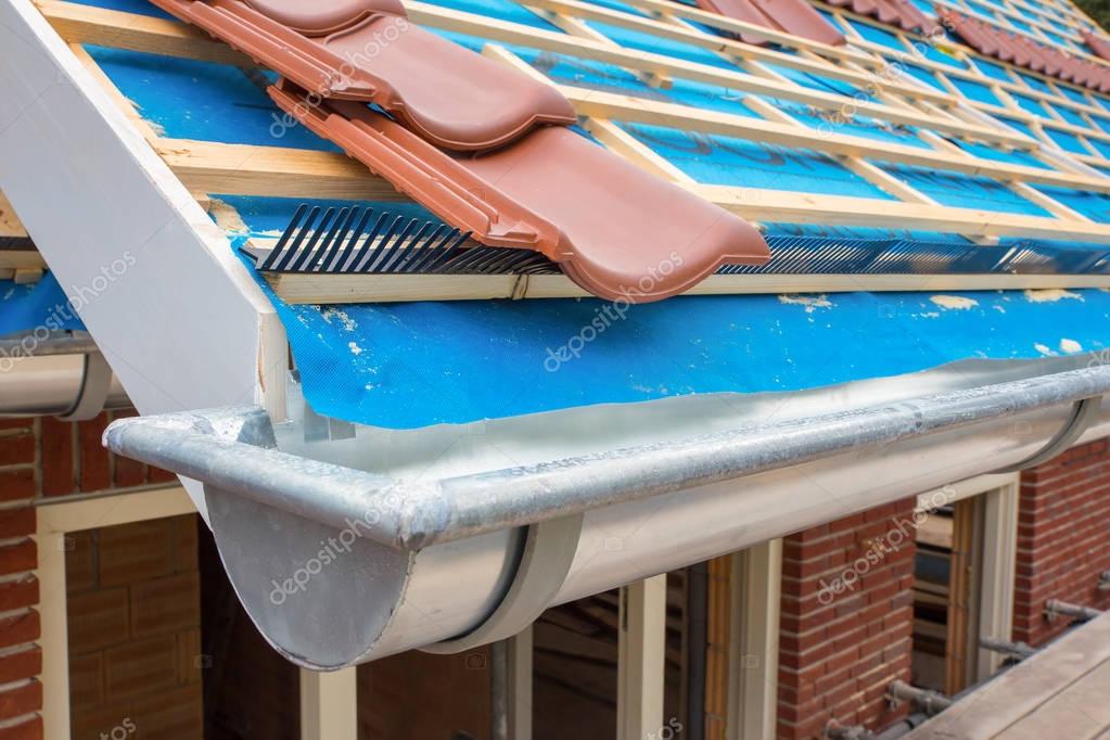 Zinc gutter and tiles on roof pitch of house — Stock Photo