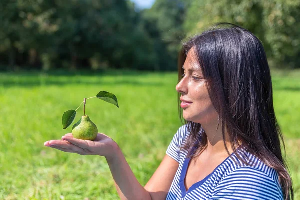 Colombiana donna guardando pera a portata di mano al di fuori — Foto Stock