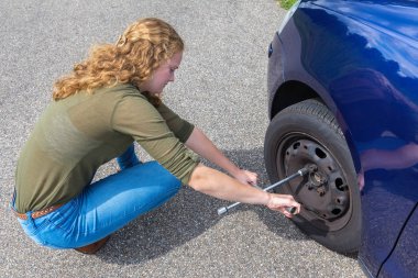 Genç Hollandalı kadın yolda araba lastik değiştirme
