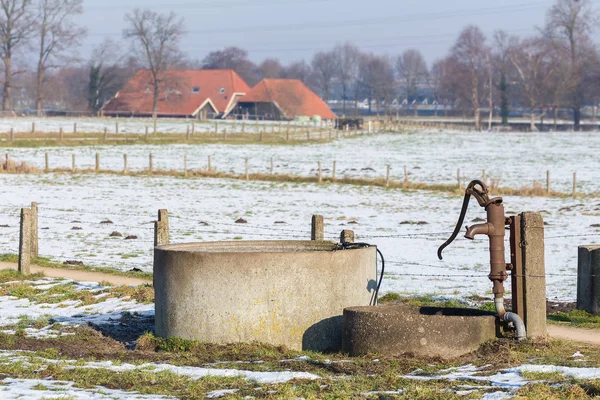 Bomba de água e bem na paisagem de neve de inverno — Fotografia de Stock