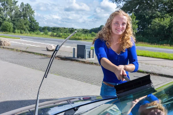 Młoda Holenderka mycia przedniej szyby samochodu — Zdjęcie stockowe