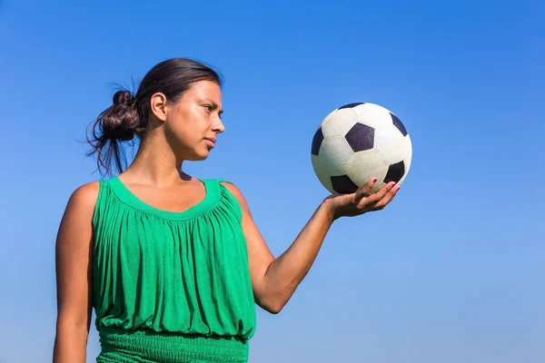 Jovem mulher segurando futebol na mão com céu azul — Fotografia de Stock