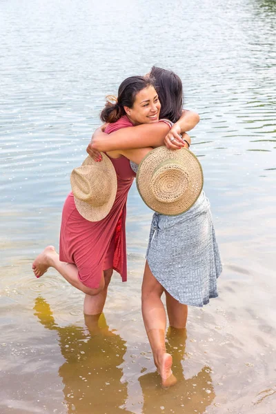 Duas mulheres abraçando-se na água — Fotografia de Stock