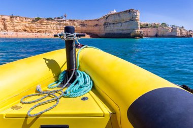 Sarı tekne sahil taşlara doğru yelken