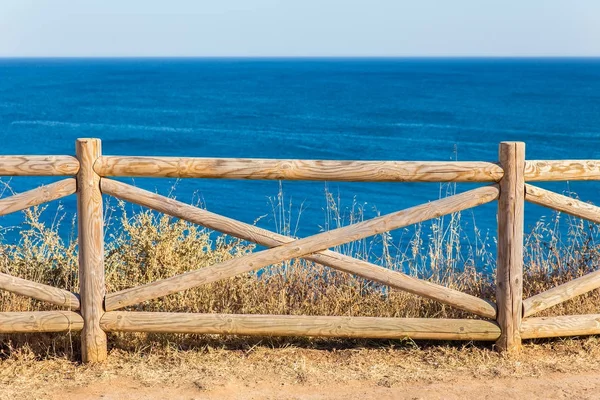 Recinzione in legno a costa con mare blu — Foto Stock