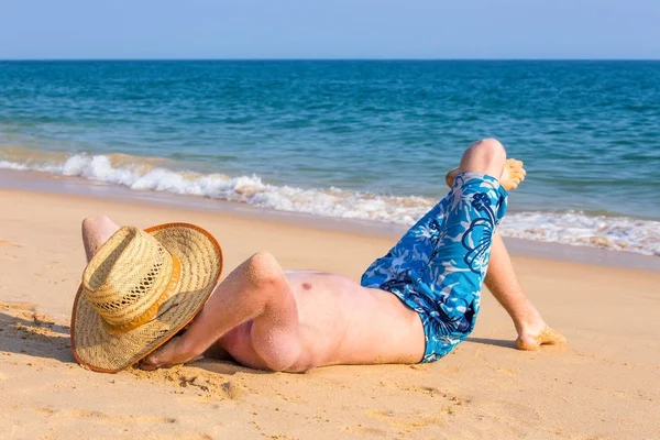Młody turysta opalając się na plaży z widokiem na morze — Zdjęcie stockowe