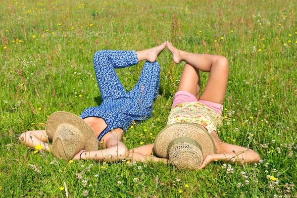 Dois amigos deitados juntos no prado — Fotografia de Stock