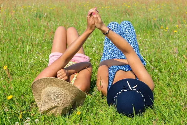 Dva přátelé, které leží vedle sebe v zelené trávě — Stock fotografie