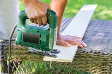 Kadın ahşap tahta elektrikli testere ile kesme