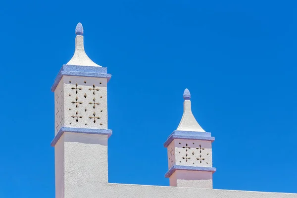 Elegantní bílé komíny v modré obloze — Stock fotografie