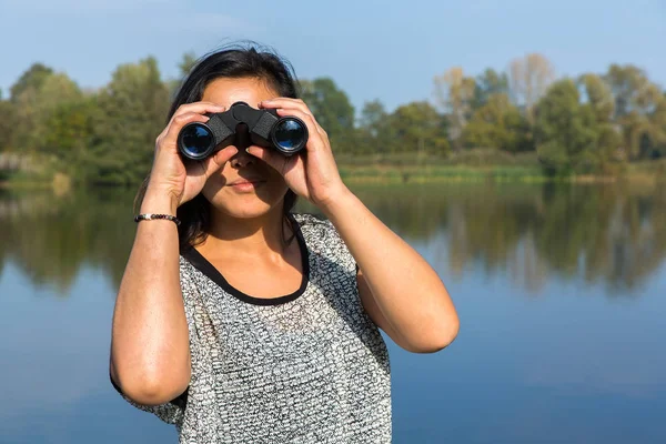 Mujer mirando a través de prismáticos en el paseo marítimo — Foto de Stock
