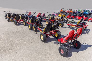 Many go-karts parked on asphalt terrain clipart