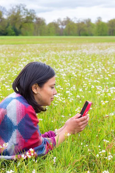 Lying woman phones in flowering meadow — Stock Photo, Image