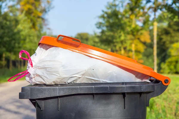 Fylld soptunna står i naturen — Stockfoto