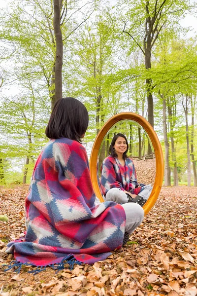 Kobieta siedzi w lesie z lustrem wiosną — Zdjęcie stockowe